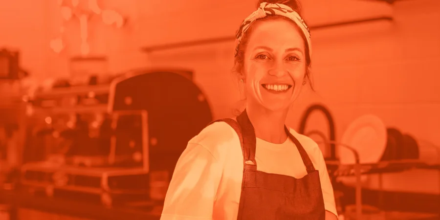 Lachende Gastronomin in ihrer Restaurant-Küche | Drinkport
